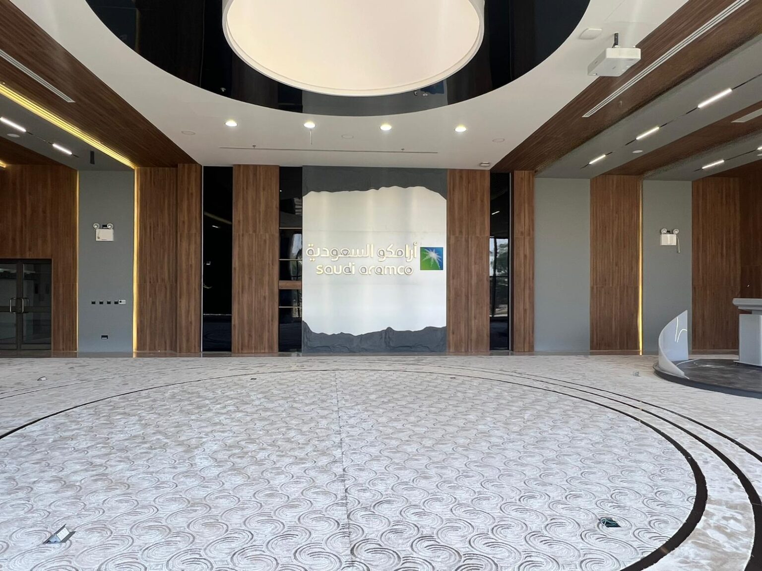A modern presentation hall with floor-to-ceiling windows, a podium, and stylish wooden accents.